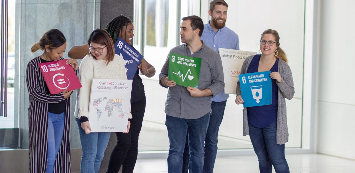 Group of people holding signs about CSR and SDG