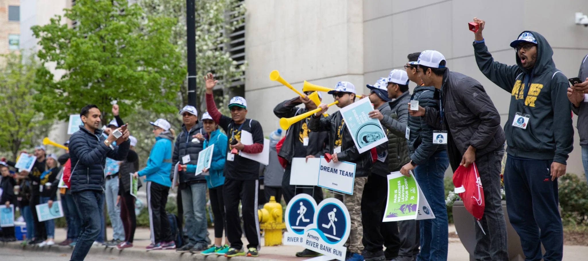 people on the sidewalk cheering on runners for the Amway River Bank Run