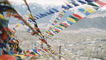 a few strings of different color flags along a mountain