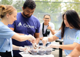 Crowe employees icing cupcakes