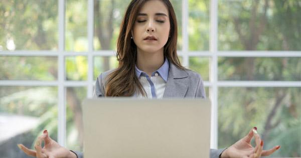 a woman meditating in front of her laptop