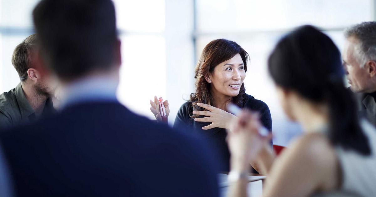 coworkers smiling in a meeting discussing