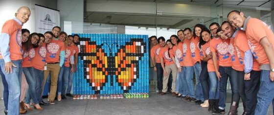 group of volunteers in front of stacked banns that make a butterfly