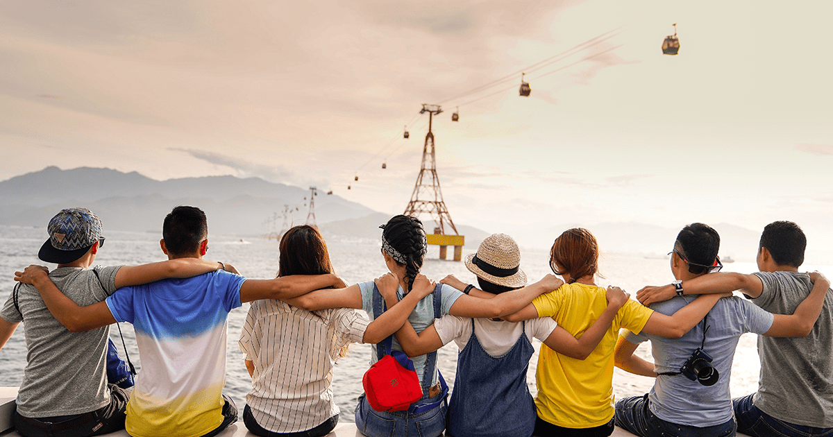 a group of people with their arms over each other shoulders looking out at a trolly