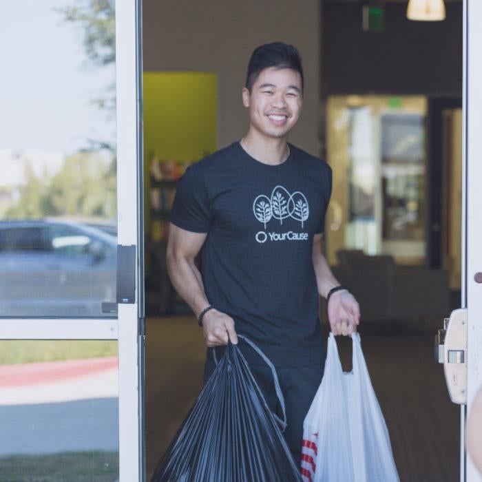 a volunteer holding two bags of donations