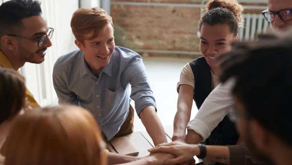 a group of people putting their hands together in a circle