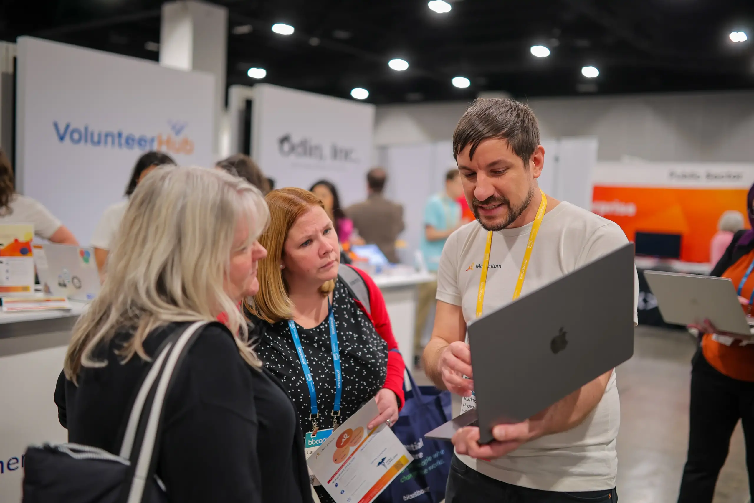 a team member showing bbcon attendees something on his laptop